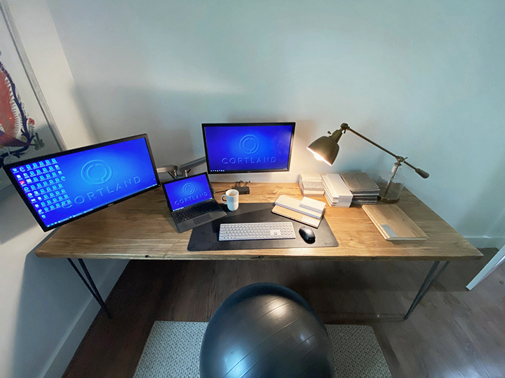 Desk area with computers, lamp and yoga ball