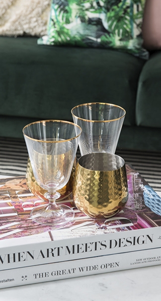 Two glasses and a cup sitting on a stack of books