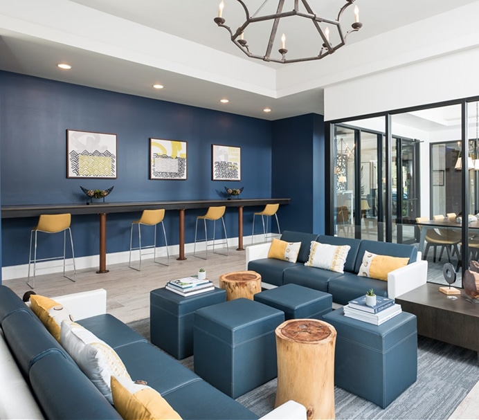 Living area with blue couches and ottomans